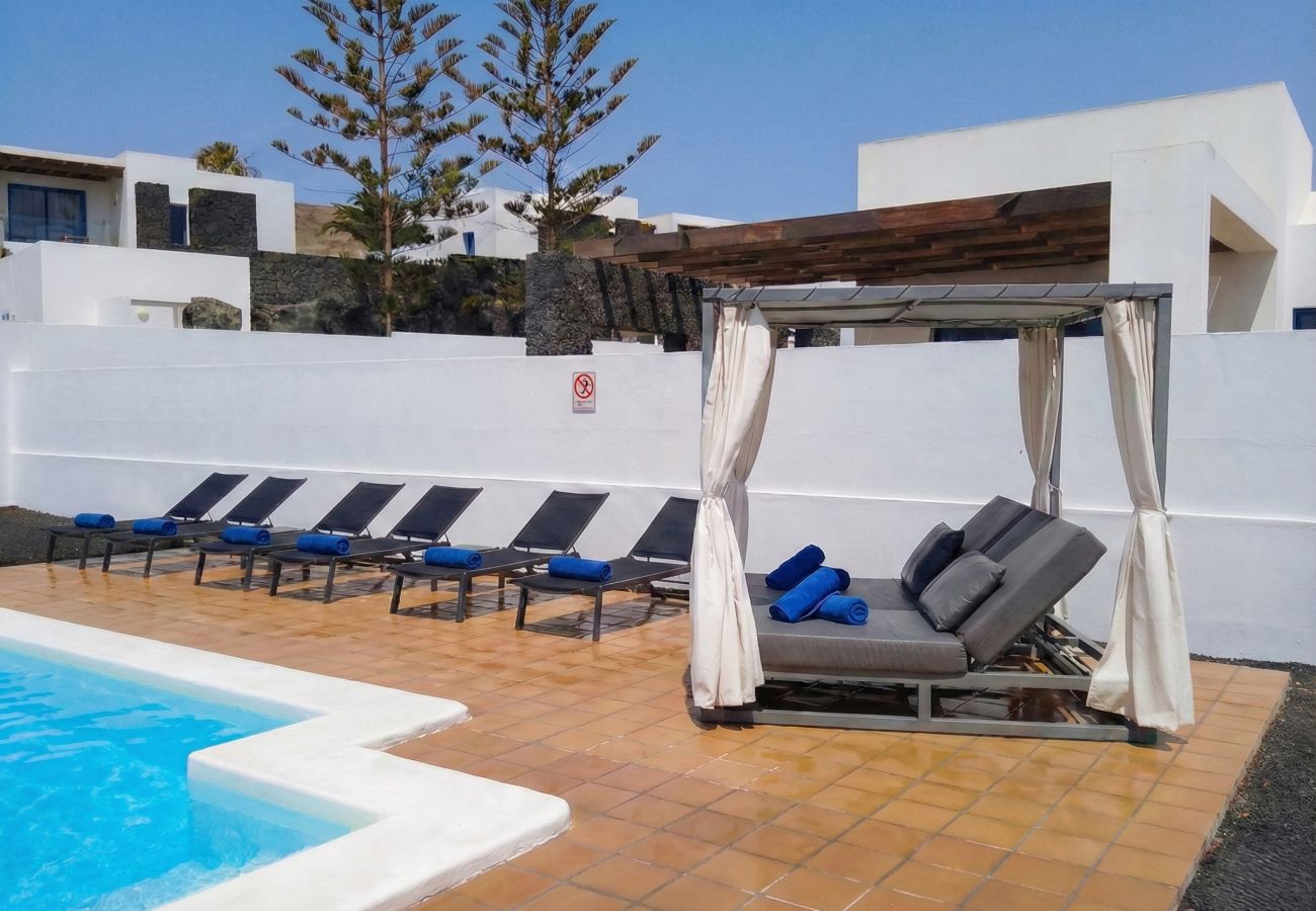 Cama balinesa y tumbonas junto a la piscina