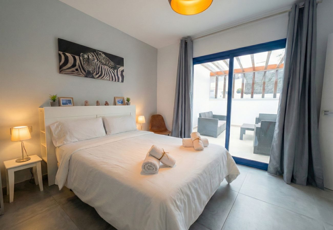 Habitación con cama blanca y puertas de cristal