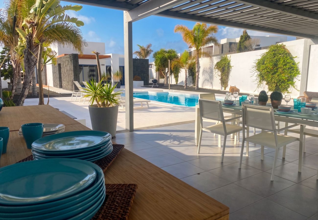 Zona de terraza techada con muebles en Villa Julia