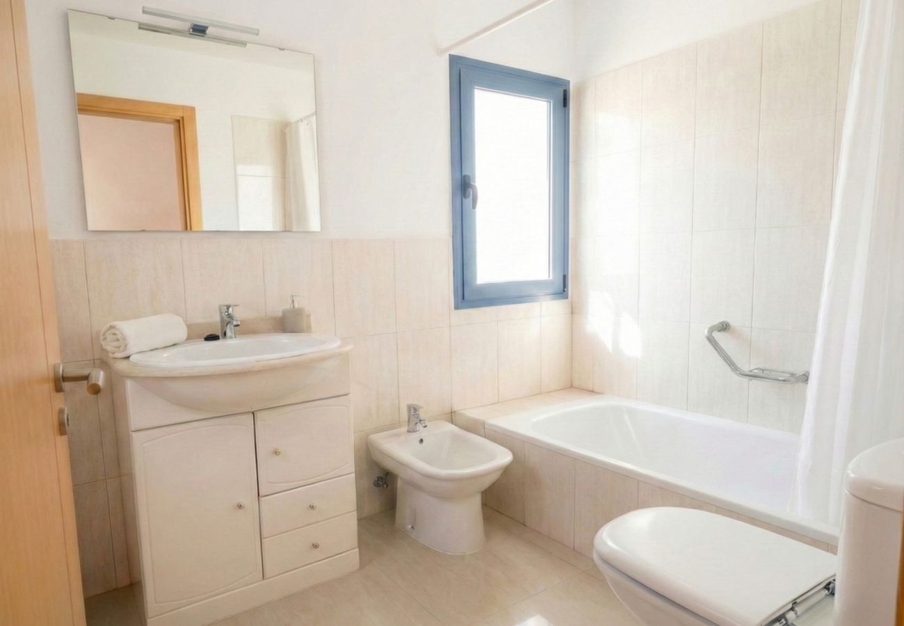 Cuarto de baño luminoso con bañera y lavabo