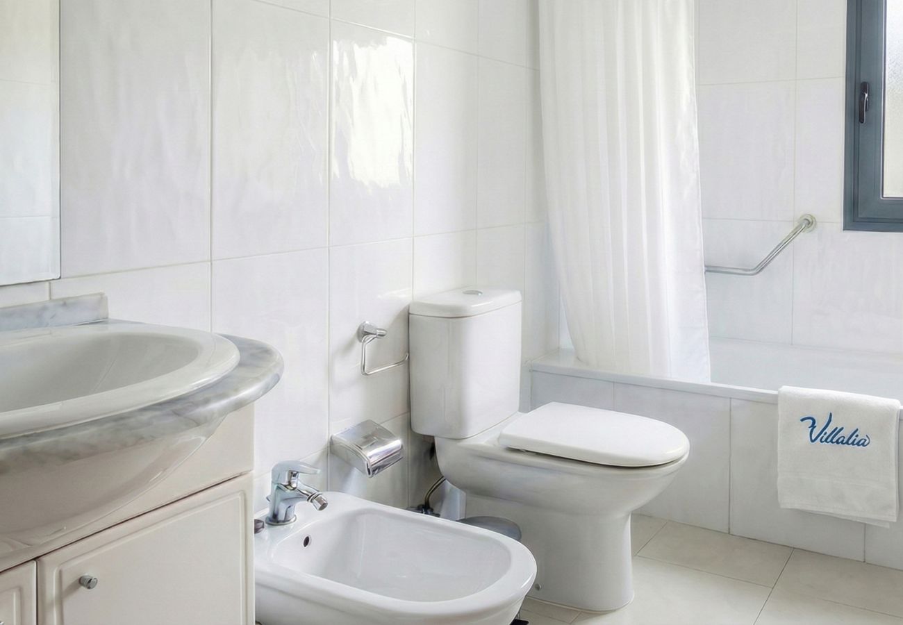 Baño blanco con inodoro, bidé y lavabo