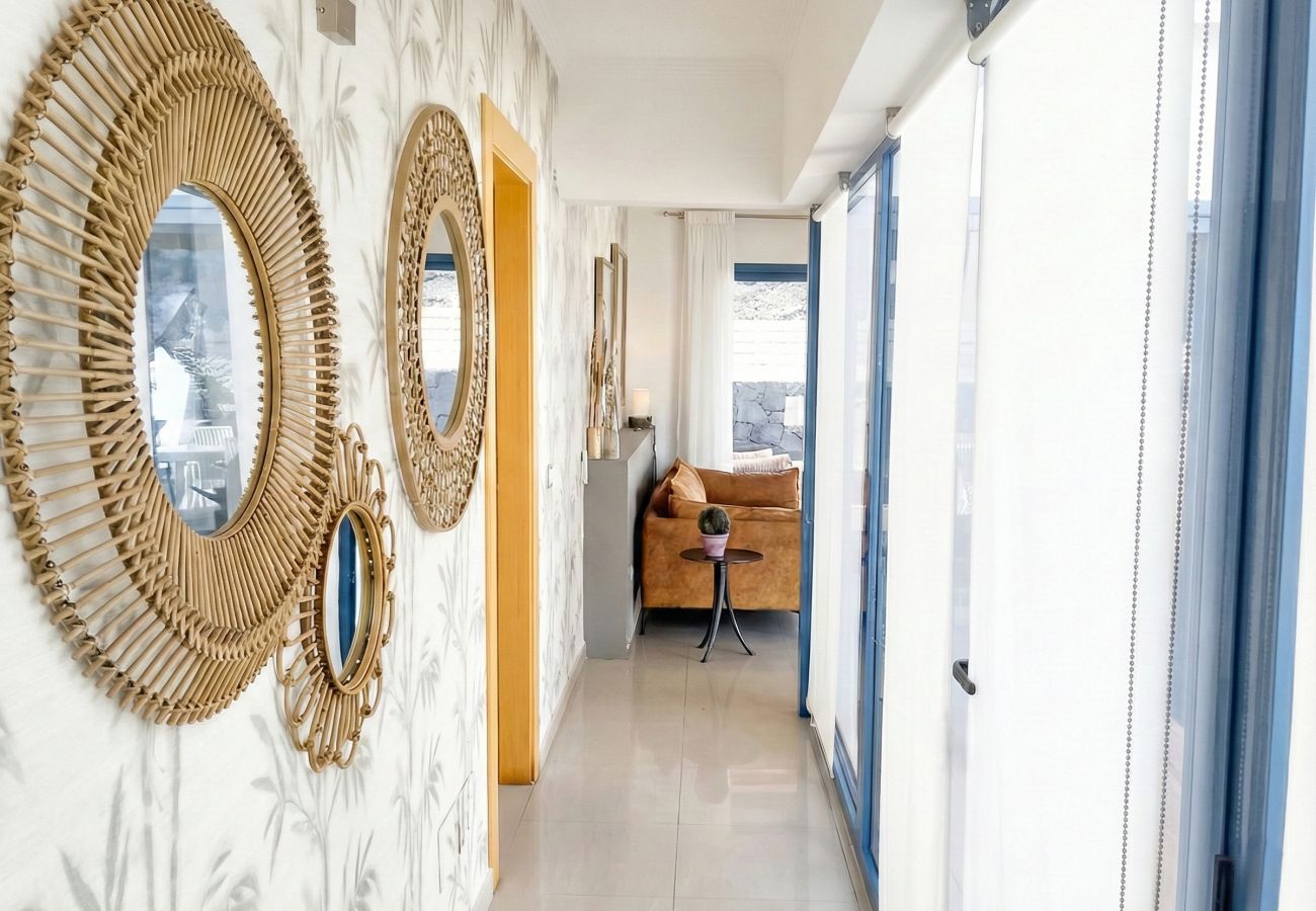 Pasillo interior blanco con tres espejos de mimbre en la pared