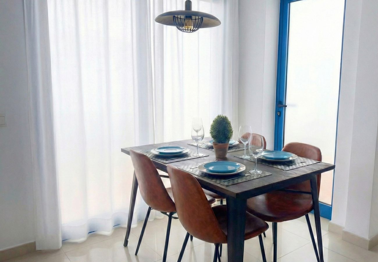 Mesa de comedor con sillas marrones en estancia luminosa