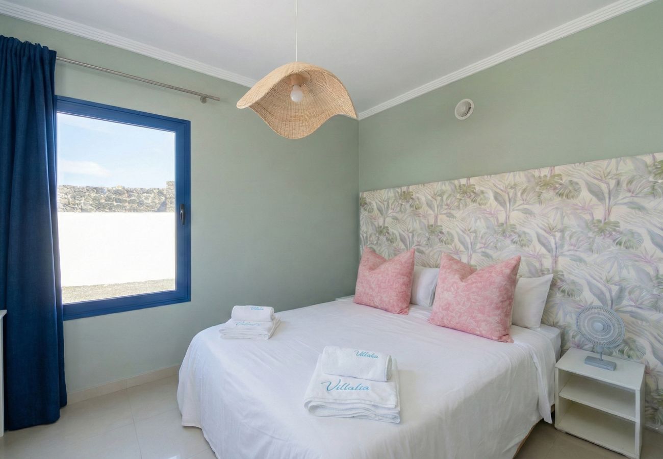 cDormitorio con cama doble y pared decorada