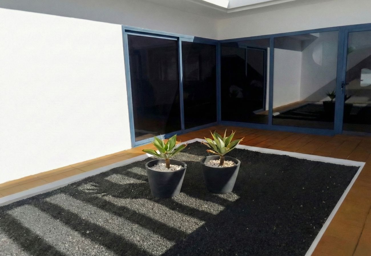 Patio interior con grava y macetas