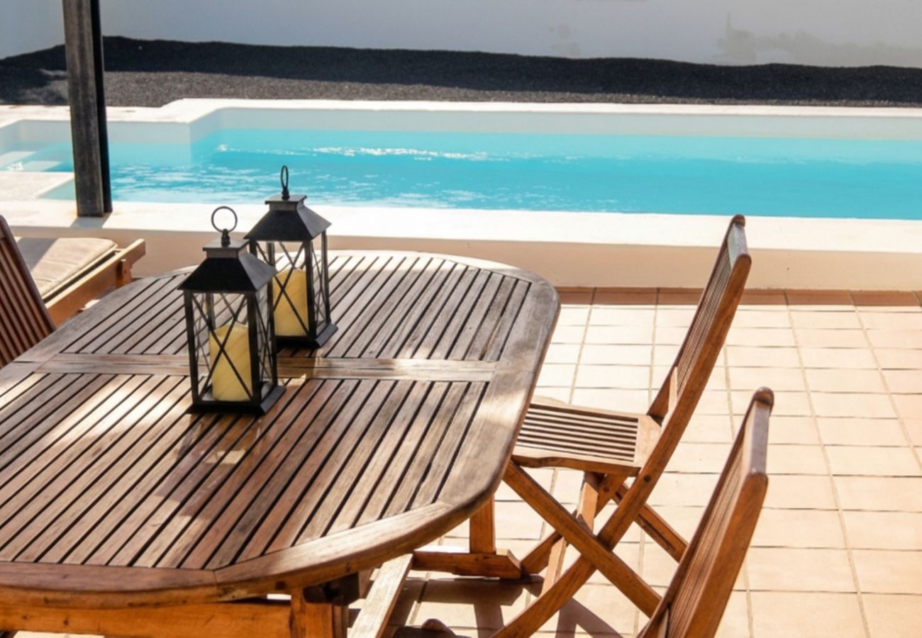 Mesa de comedor de madera en la terraza de la piscina