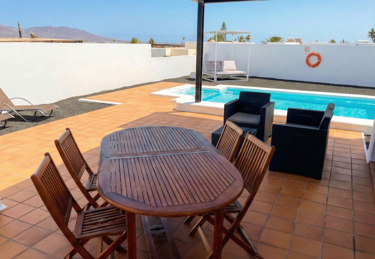 Vista general de la terraza con piscina y mesa