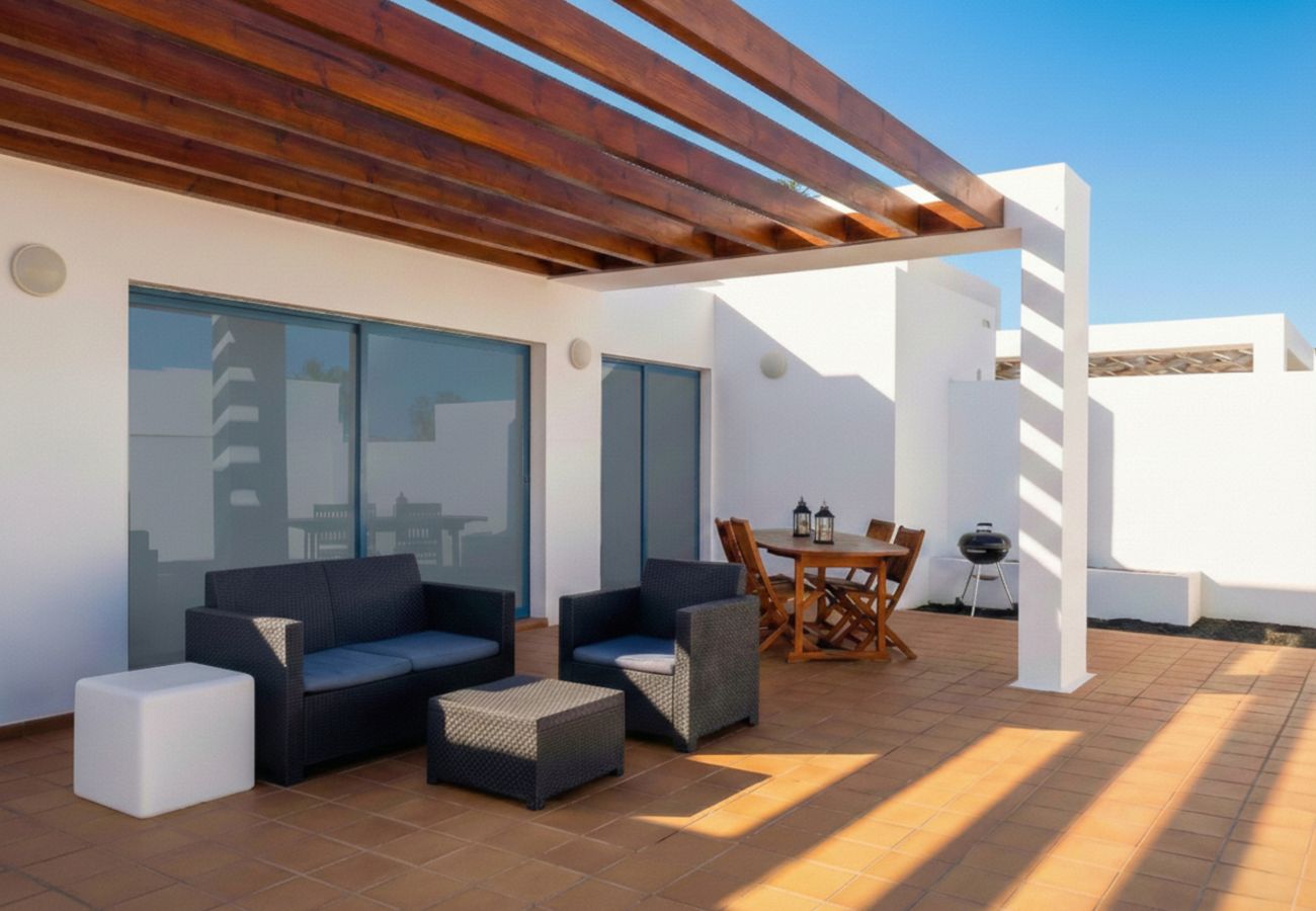 Sofás de exterior modernos bajo pérgola de madera