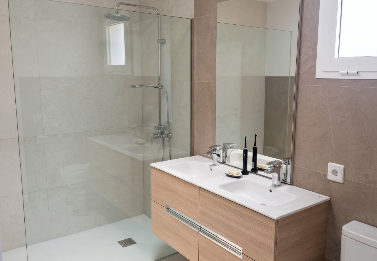 Lavabo blanco sobre mueble madera baño