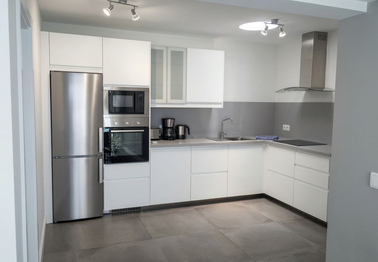 Cocina gris y blanca con electrodomésticos