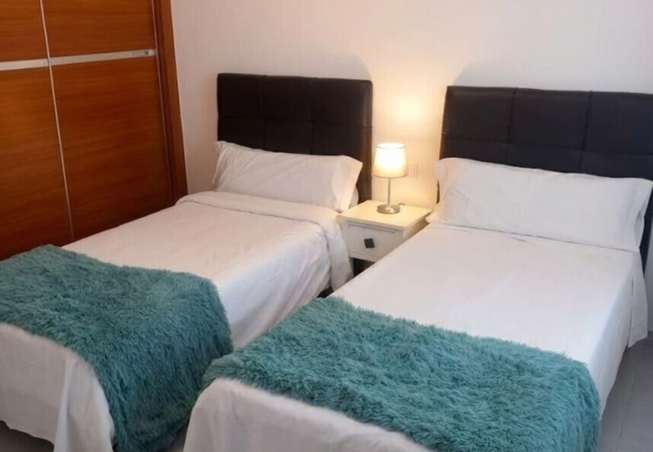 Dos camas individuales con mantas turquesas en Villa Marina