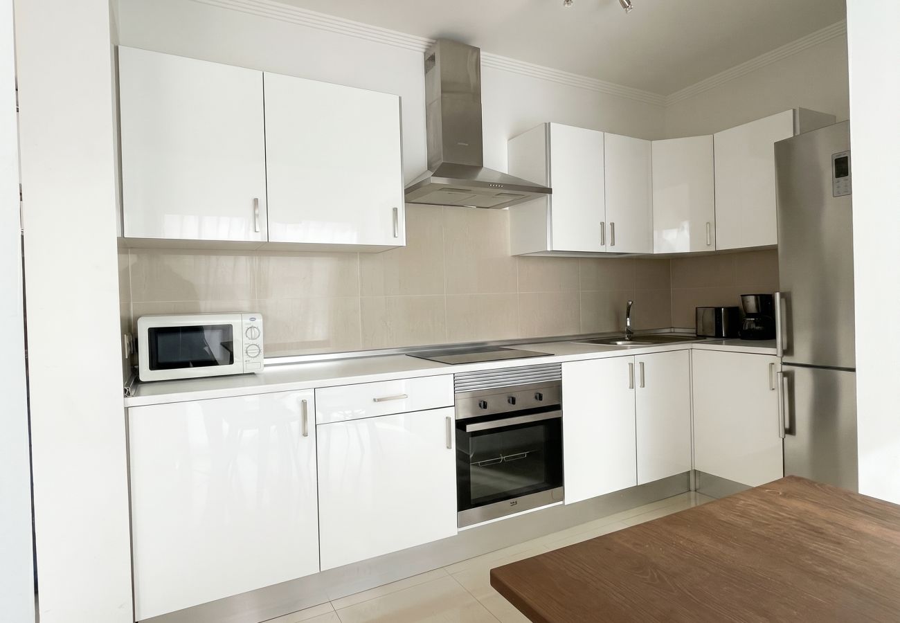 Cocina moderna blanca completamente equipada en villa.