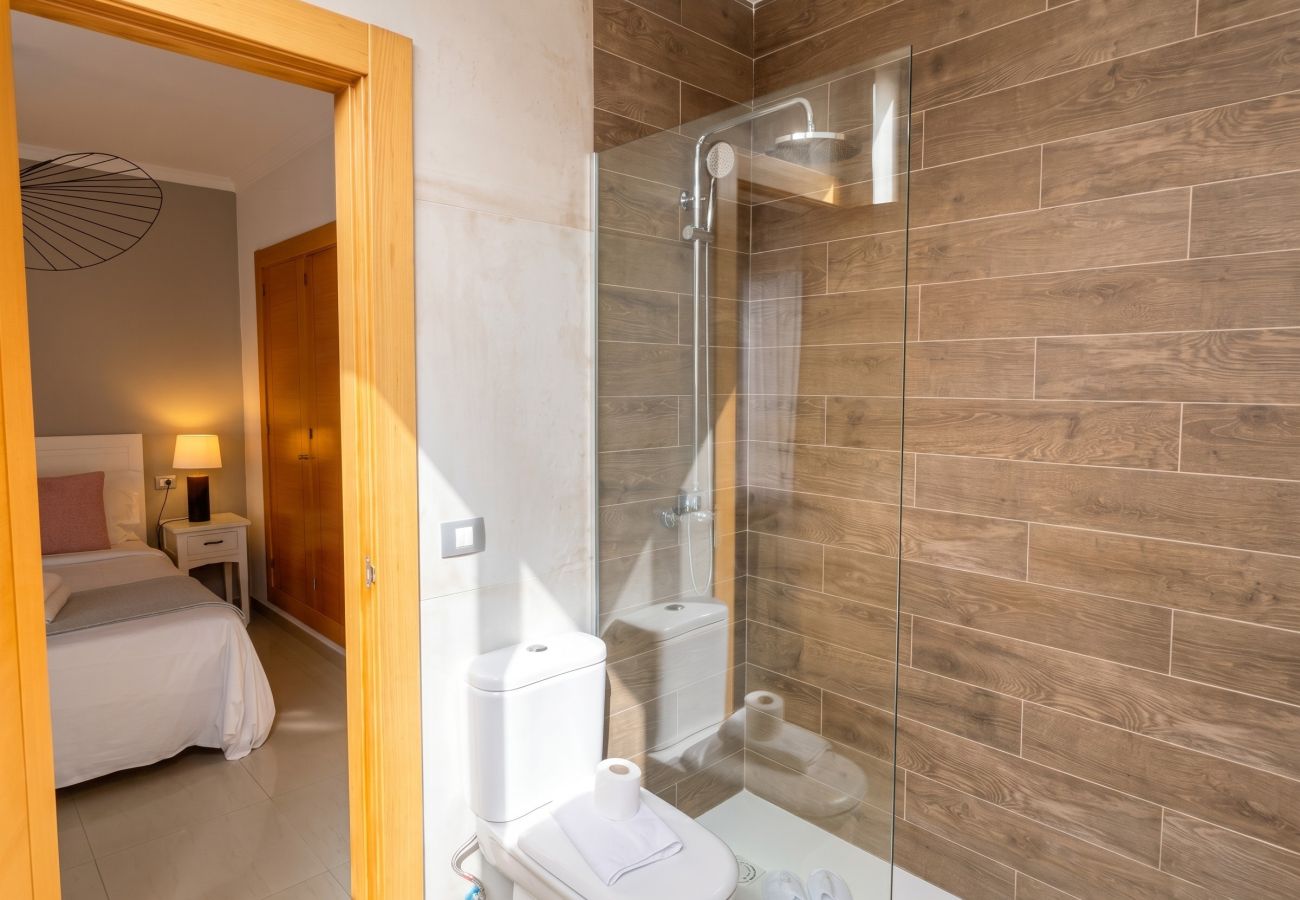 Baño en suite con ducha y acceso al dormitorio.