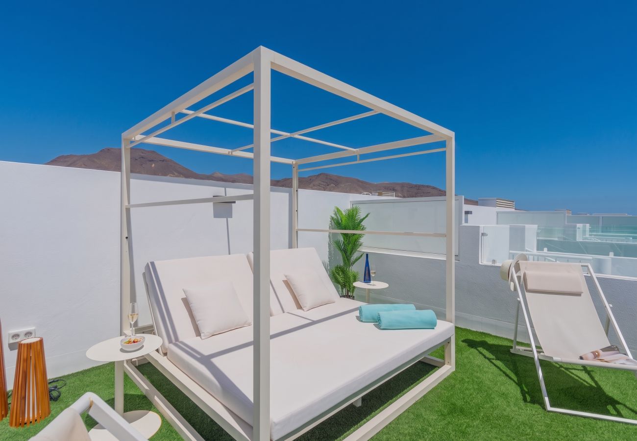 Cama balinesa blanca y tumbonas en el solárium de Villa Serena Silgar