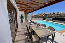 Piscina privada y zona de comedor exterior en Villa Capri