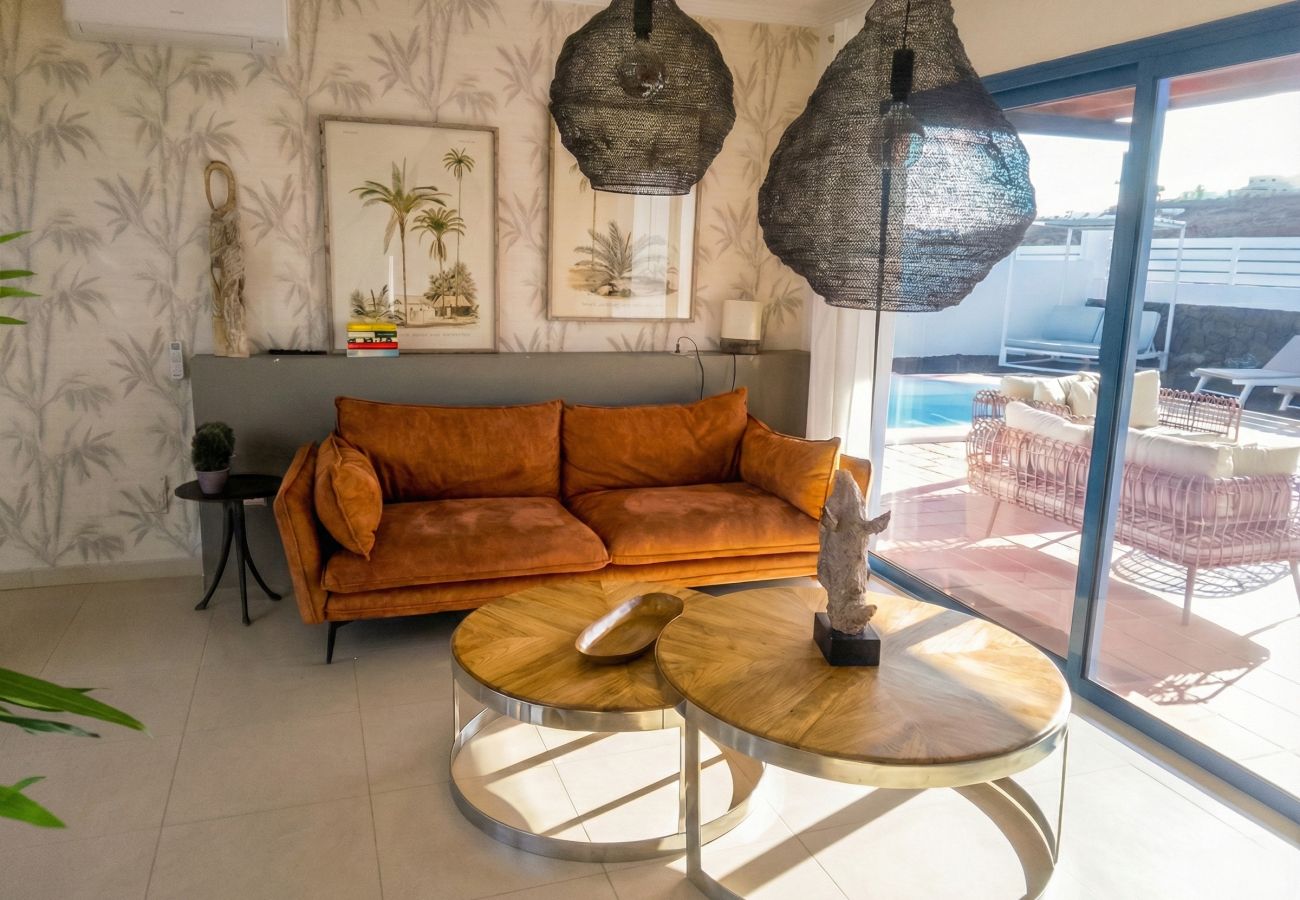 Living room with brown sofa, round table and wicker mirrors