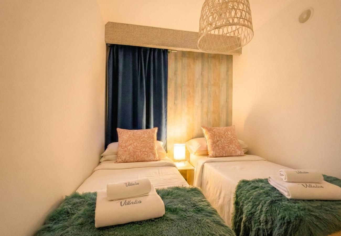 Single beds with headboard and warm lighting