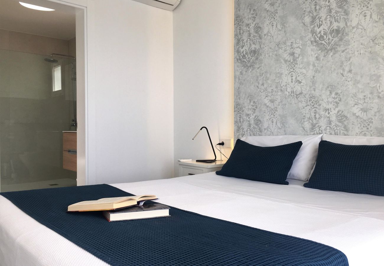 Double bed with blue cushions and decorated wall