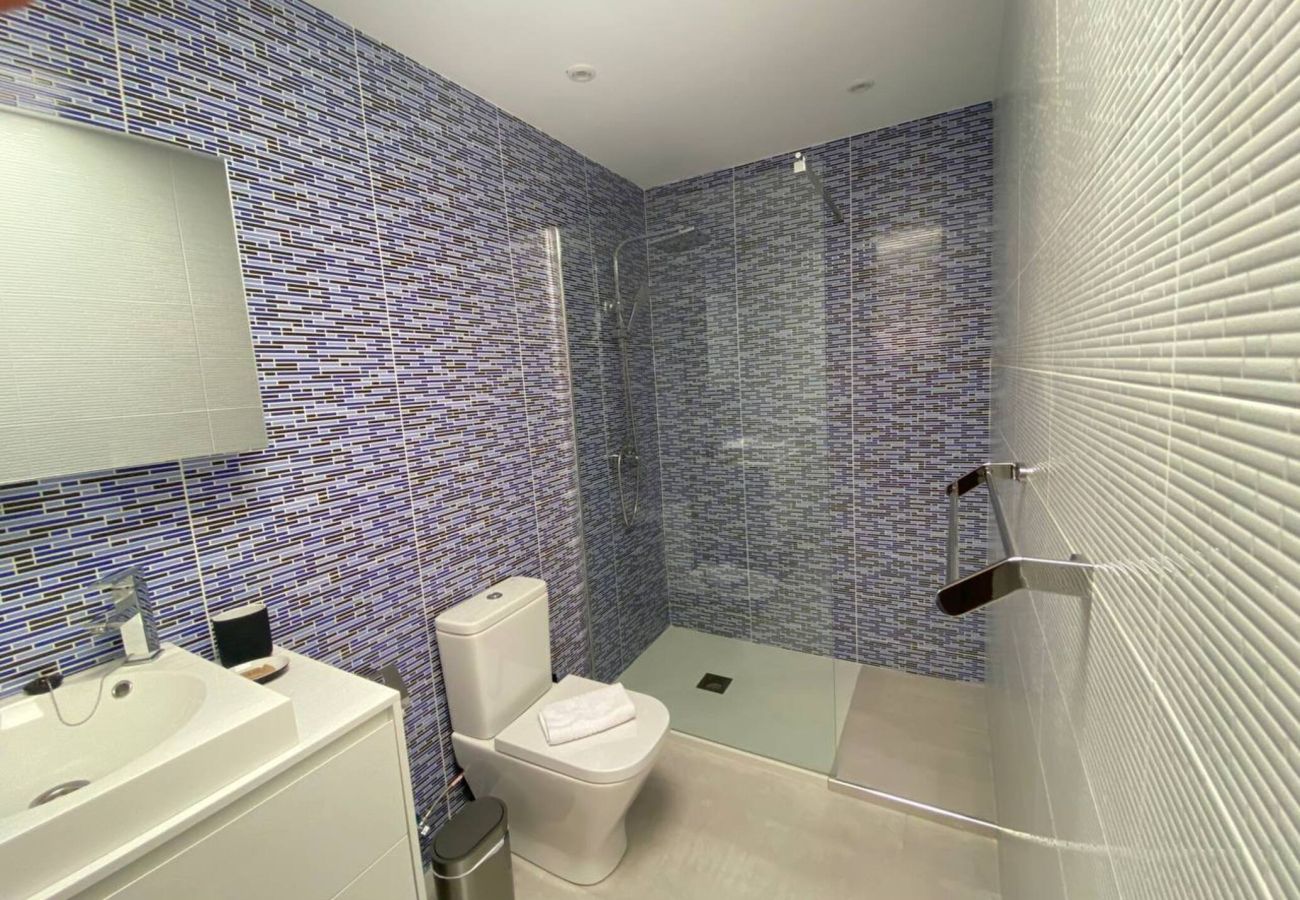 Bathroom with blue tiles and shower at Villa Marina Lanzarote