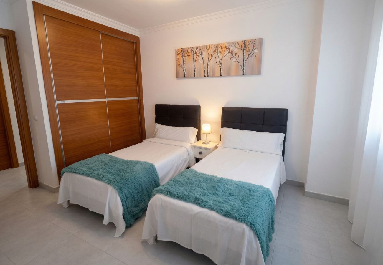 Two single beds with turquoise blankets at Villa Marina