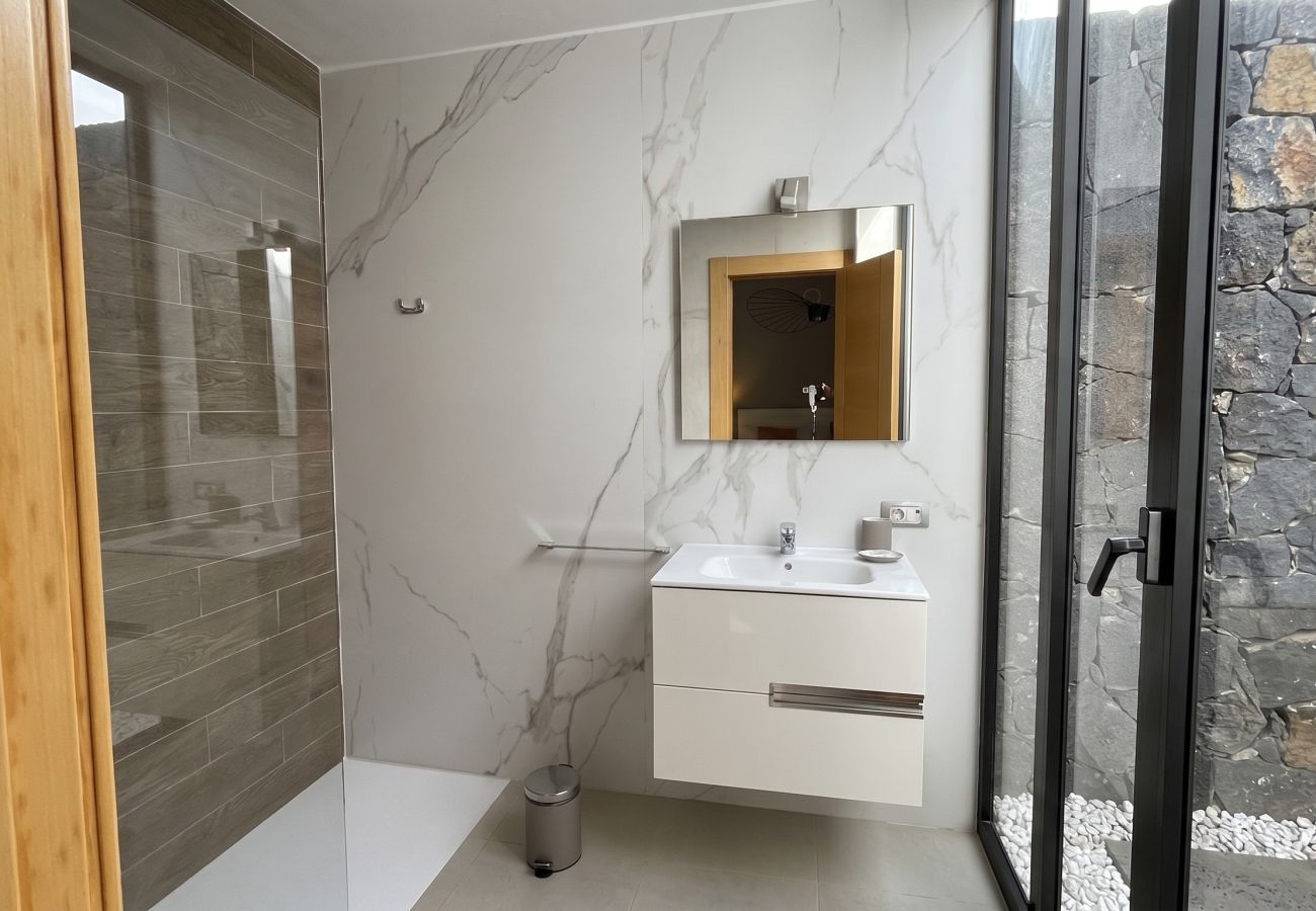 Bathroom with modern sink and window to a stone patio.