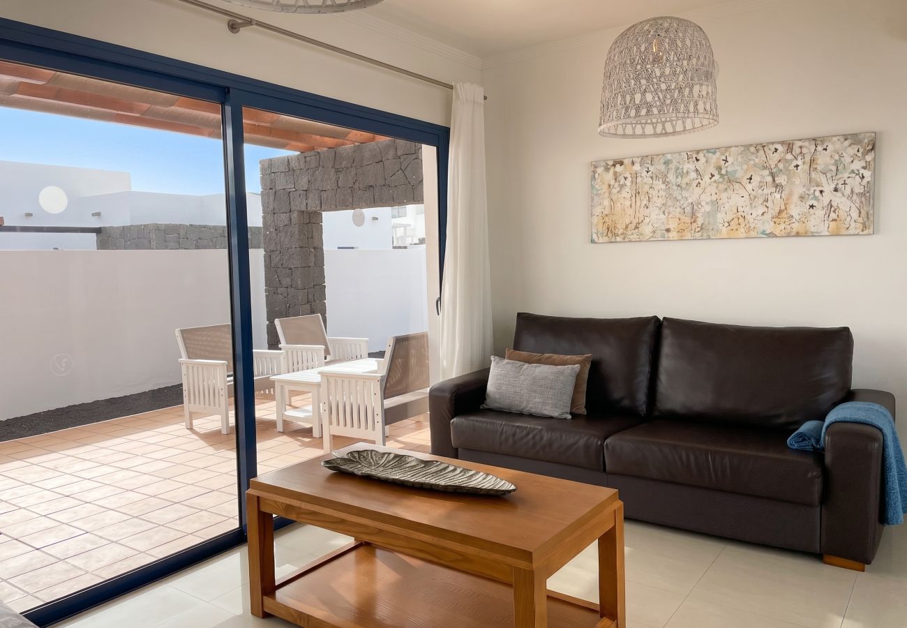 Bright living room with sofa and large windows to the pool.