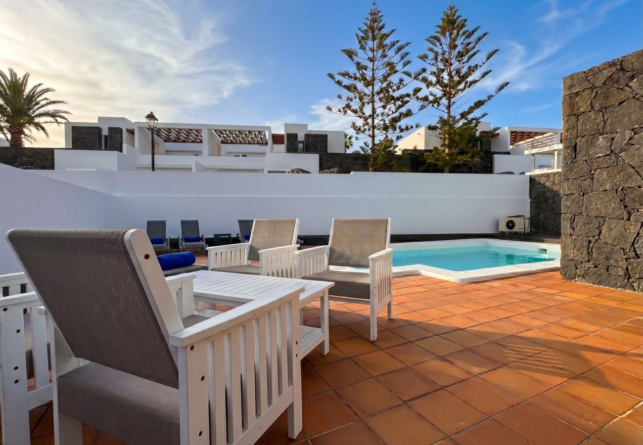 Sunny terrace with outdoor dining and pool views.