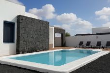 Piscina privada con muro de piedra volcánica en Villa Ancor, Lanzarote